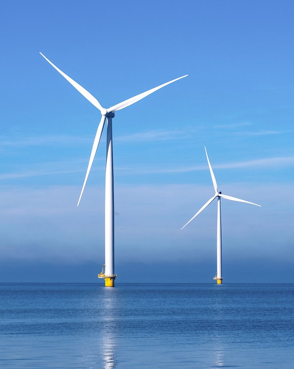 Windmill park with clouds and a blue sky, wind mill turbines in the ocean aerial view of a wind farm in the Nehterlands production clean energy